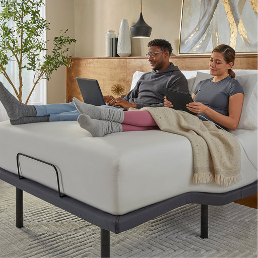 Couple working on laptops on a mattress raised by the baselogic Pearl Adjustable Base