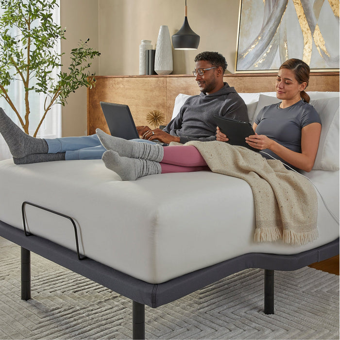 Couple working on laptops on a mattress raised by the baselogic Pearl Adjustable Base