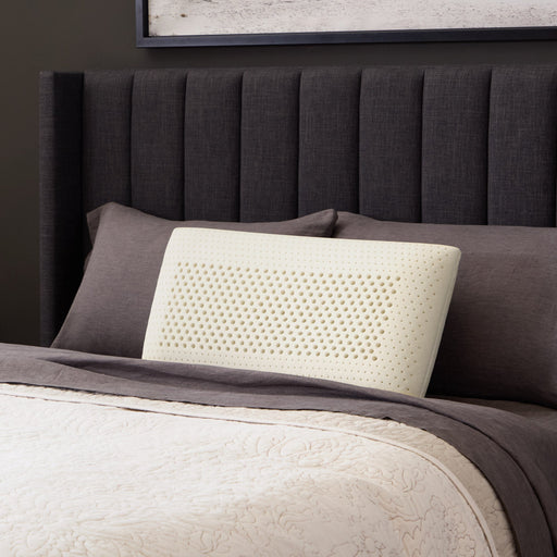 Malouf Zoned Talalay Latex Pillow latex core on a bed, three-quarter view