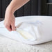Hand unzipping the removable cotton cover of the Malouf Zoned Talalay Latex Pillow