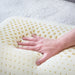 Hand pressing into the springy Talalay latex of the Malouf Zoned pillow